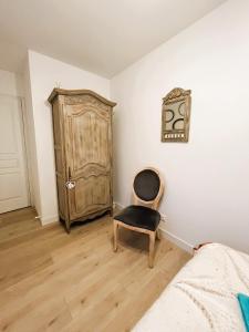a bedroom with a chair and a cabinet at Halte romantique in Ault