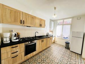 a kitchen with wooden cabinets and a white refrigerator at Halte romantique in Ault