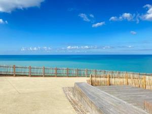 a wooden bench sitting on top of a beach at Halte romantique in Ault