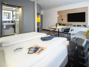 a hotel room with two beds and a tv at Novotel Suites Wien City Donau in Vienna