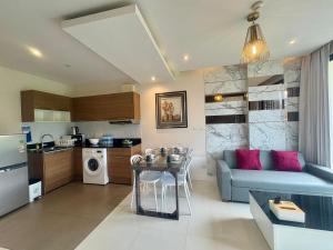 a kitchen and living room with a couch and a table at The Lago Nai Harn 2 BR-Walk to beach in Rawai Beach