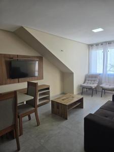 フォルタレザにあるResidencial Amoraのソファ、テレビ、テーブルのあるリビングルーム