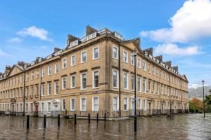 a large building in the middle of a flooded street at Prime Location! 1-Bed Flat Near All Attractions in Bath
