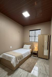 a bedroom with a large bed and a window at Lar Bernardes COP 30 in Belém