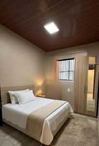 a bedroom with a large bed and a window at Lar Bernardes COP 30 in Belém +1 photo