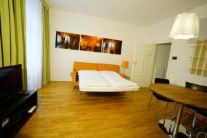 a living room with a bed and a table at Schlossquadrat Apartment 17 in Vienna