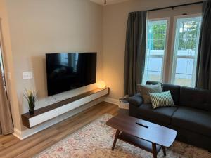 a living room with a couch and a flat screen tv at Tide's Turn Retreat in Cedar Point