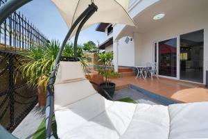 a white couch sitting on the balcony of a house at Sunset Pool Villa in Na Jomtien