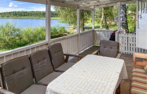 porche con mesa, sillas y vistas al lago en Beautiful Home In Tranås With Lake View, en Tranås