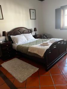 a bedroom with a bed and two night stands with two lamps at Vagos Guest House in Vagos