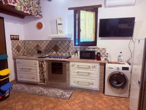 a kitchen with a washing machine and a tv at La Dimora in Formello +5 photos