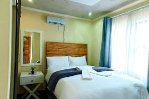a bedroom with a large white bed and a window at Seqonoka Villa Accommodation & Events Park in Berea Hills
