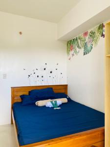 Un dormitorio con una cama azul con flores en la pared. en 2-Bedroom Ladera Suites, en Baguio