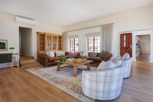 a living room with couches and a table at Villa Canetsfontein in Wellington