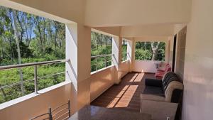 a living room with large windows and a couch at Coco Resort Yercaud - K HOTEL in Yercaud +18 photos