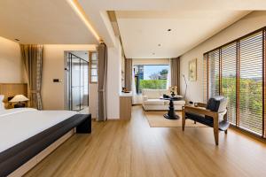 a bedroom with a bed and a living room at Tree House Dali 清朴小院 大理 in Dali Airport