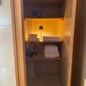 a closet with towels and a lamp in a bathroom at Civico 48 in Vizzola Ticino +11 photos