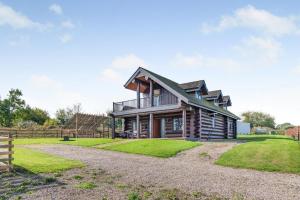 Thornton Watlassにある3 Bed in Thornton Watlass oc-s32783の柵と芝生のある丸太小屋