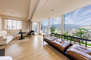 a living room with a couch and large windows at Tree House Dali 清朴小院 大理 in Dali Airport