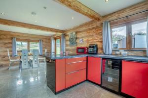 Thornton Watlassにある3 Bed in Thornton Watlass oc-s32783のキッチン(赤いキャビネット、テーブル、椅子付)