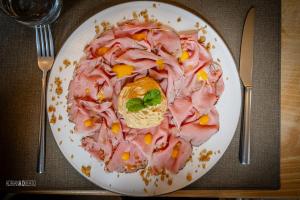 a plate of food with ham on a table at Locanda Del Mulino in Pamparato