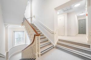 una scala in una casa con pareti bianche e una finestra di Boutique Bath Apartment, Minutes from Shops & Spas a Bath