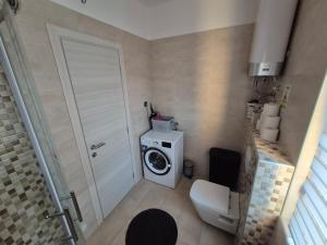 a small bathroom with a washing machine and a washer at Apartmani Nika in Rijeka +15 photos