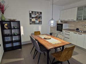 a kitchen with a wooden table and chairs at Apartmani Nika in Rijeka
