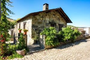 an old stone house on a cobblestone street at Ninho do Melro - Turismo Rural Bragança in Bragança