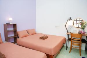 a room with two beds and a desk with a mirror at An house Ninh Binh in Ninh Binh