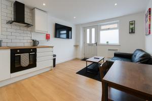 レスターにあるRentals Leicester 4 - Free Street Parkingのソファとテーブルのあるキッチンとリビングルーム