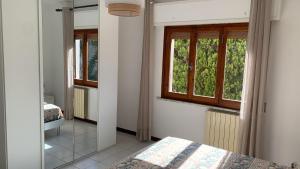 - une chambre avec un lit et 2 fenêtres dans l'établissement Villino La Pergola, à Marina di Campo Airport