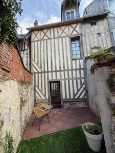 Un edificio antiguo con un patio con mesa y sillas. en Studio centre historique d'Honfleur, en Honfleur