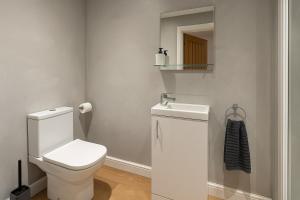 レスターにあるRentals Leicester 4 - Free Street Parkingの白いトイレと鏡のあるバスルーム