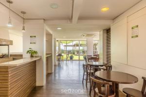 Un restaurante con mesas y sillas y un mostrador. en Apto pé na areia com vista p/ mar JBM, en Florianópolis