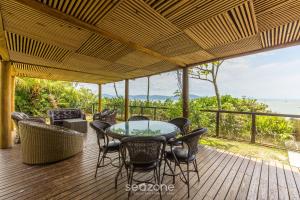 una mesa y sillas en una terraza con vistas al océano en Apto pé na areia com vista p/ mar JBM, en Florianópolis 11 fotos más