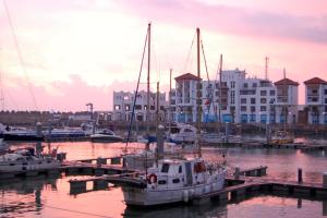 un groupe de bateaux amarrés dans un port de plaisance comportant des bâtiments dans l'établissement Superbe Appartement de Luxe Marina Agadir, à Agadir