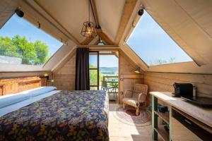 マッサ・マリッティマにあるGlamping Stregaiaの大きな窓のある部屋にあるベッドのある寝室