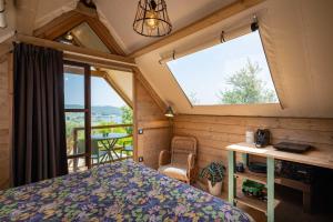 a bedroom with a bed and a large window at Glamping Stregaia in Massa Marittima