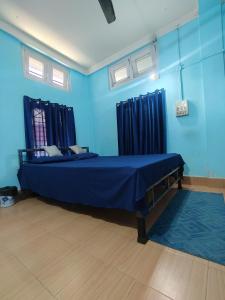 a blue room with a bed with blue walls and windows at Nest retreat in Jorhat