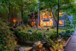 a house in the woods with a pond in the yard at A Robins Nest in Blowing Rock