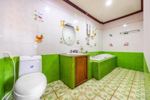 a green bathroom with a toilet and a sink at Nassen Hotel in Vientiane