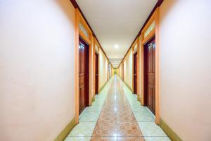 an empty hallway with wooden doors and tile floors at Nassen Hotel in Vientiane