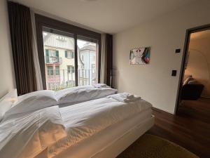 チューリッヒにあるStylish 1BR in the city center - Baron 25のベッドと大きな窓のある寝室