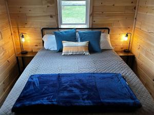 a bed in a room with a blue blanket on it at Bear Lake Retreat in Lake