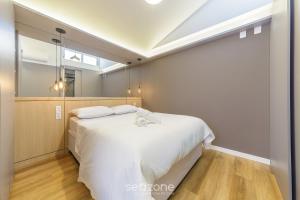a bedroom with a large white bed and a window at House with Jacuzzi, just 10min from the sea OSH in Florianópolis