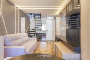 a living room with a couch and a spiral staircase at House with Jacuzzi, just 10min from the sea OSH in Florianópolis
