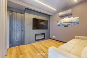 a living room with a couch and a fireplace at House with Jacuzzi, just 10min from the sea OSH in Florianópolis