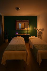 a bedroom with two beds and a mirror at Casona San Cayetano Suites & Lofts & Spa by SCE in Guanajuato