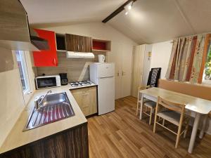 a small kitchen with a sink and a table at Camping La Pindière in Héric